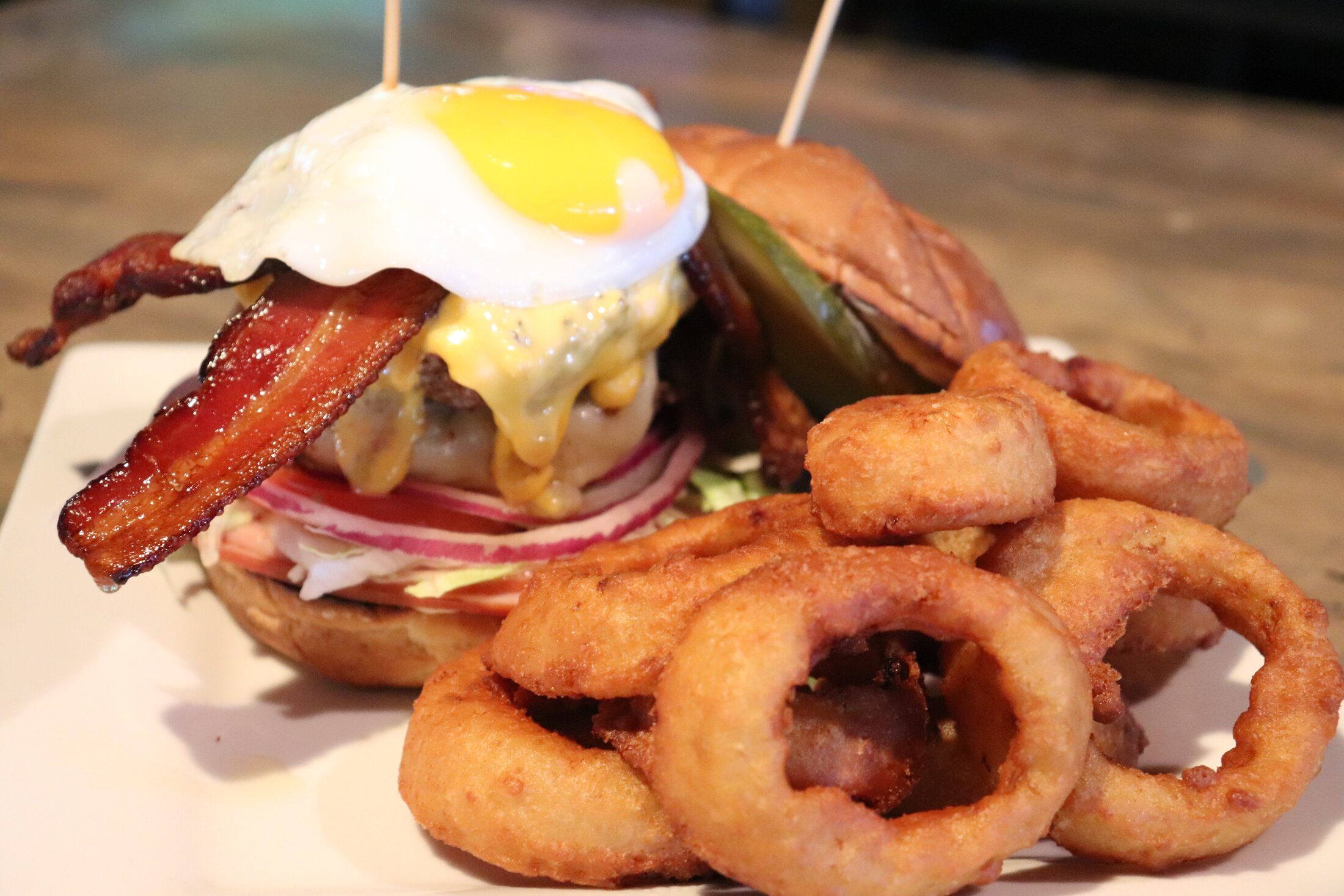 House-ground bacon and egg cheeseburger with a side of onion rings at Rooneys in Woodinville