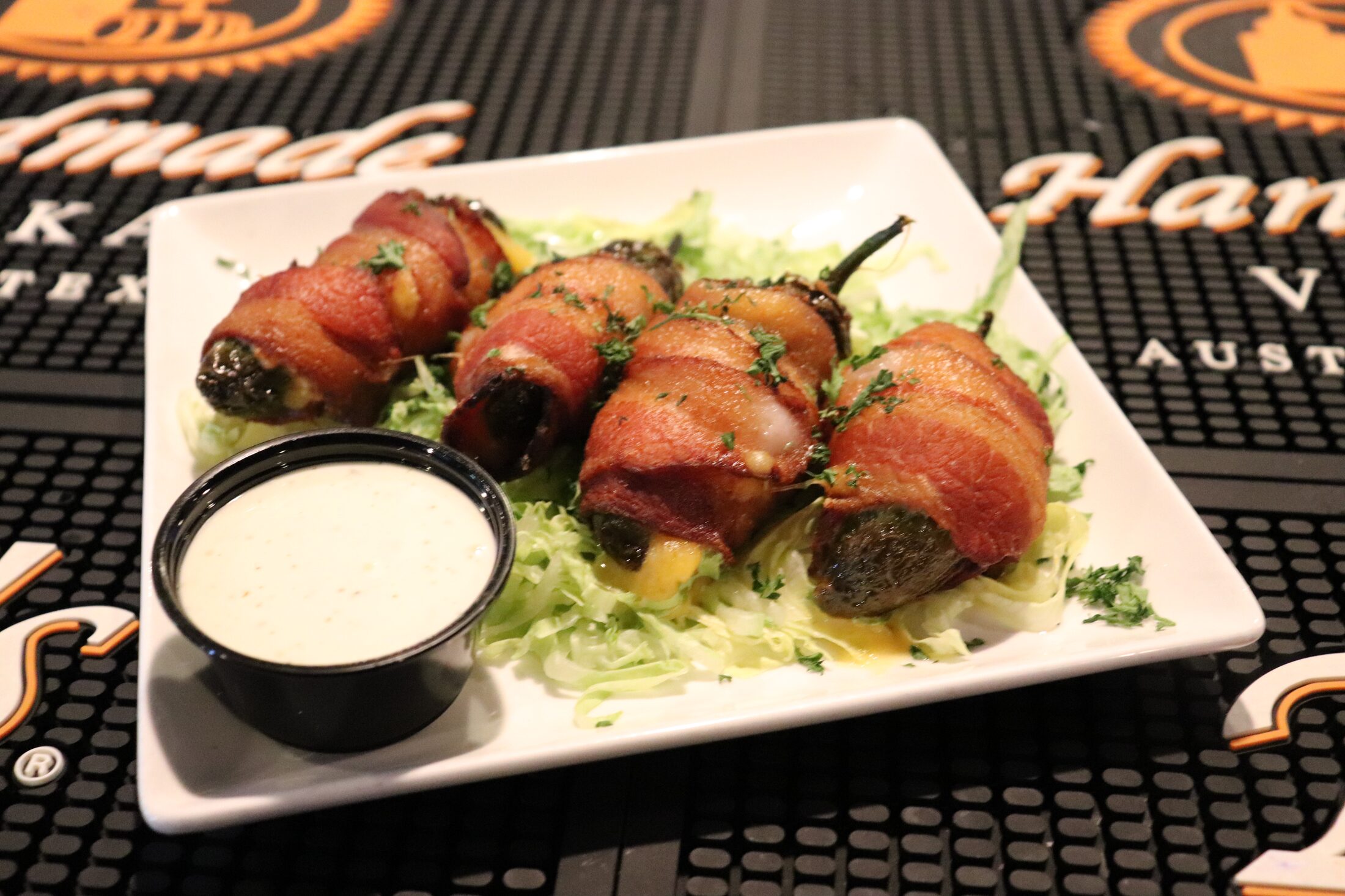 Bacon-wrapped stuffed jalapeños served with ranch at Rooneys sports bar