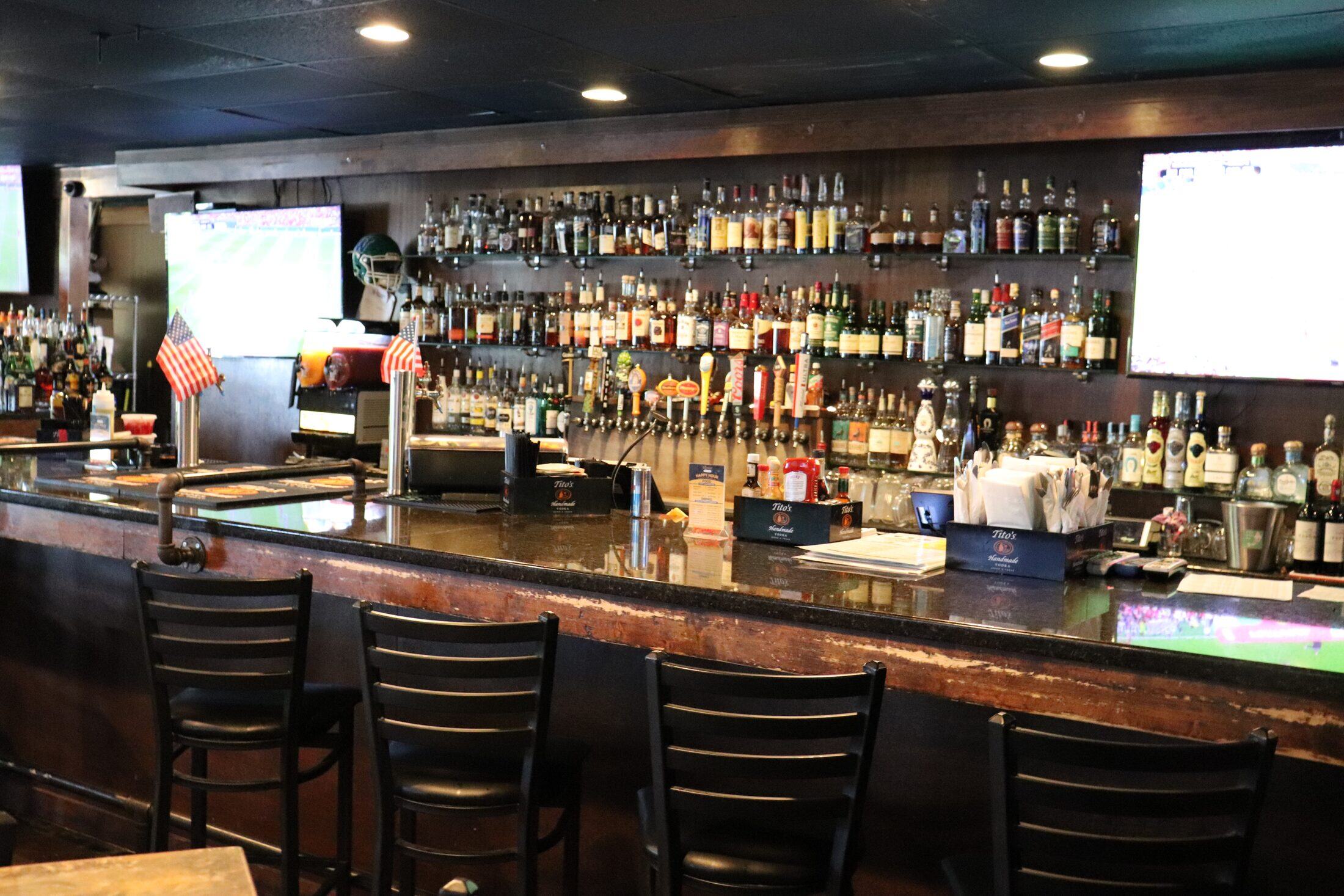 Rooneys full bar with rows of spirits and craft beer taps