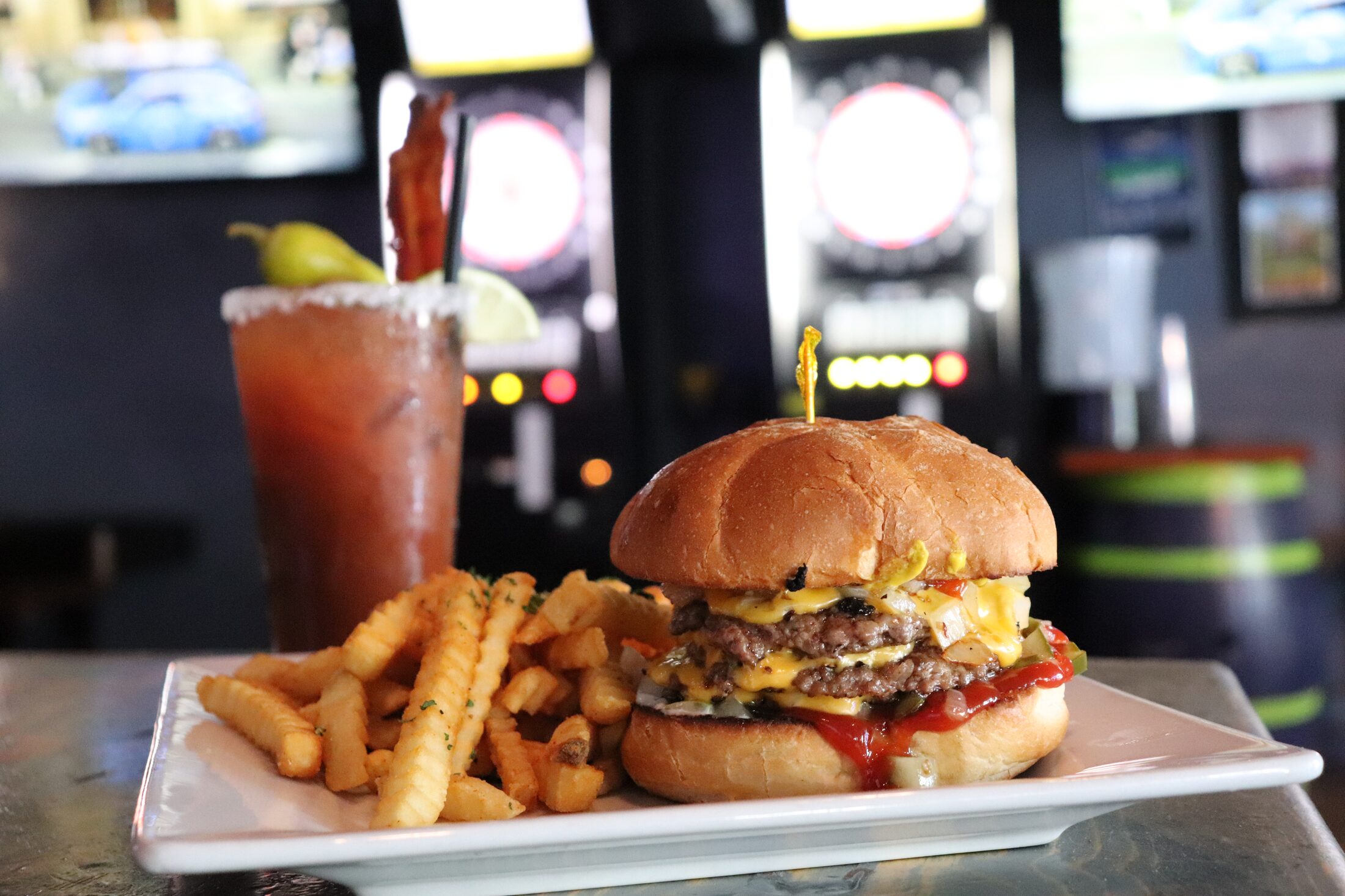 Cheeseburger with crinkle fries and a bloody mary by the arcade at Rooneys