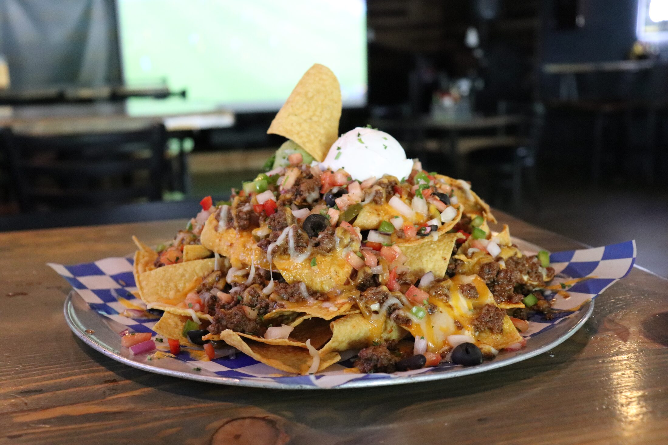 Close-up of Rooneys loaded nachos with melted cheese, jalapeños and sour cream