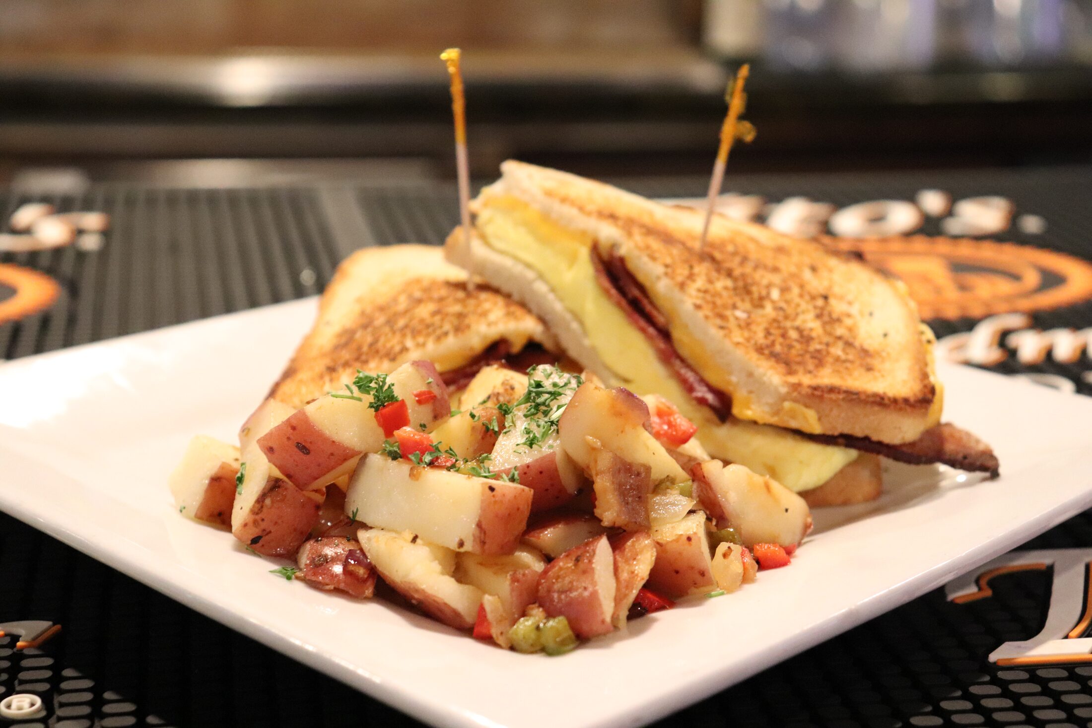 Classic patty melt on griddled rye with a side of breakfast potatoes at Rooneys