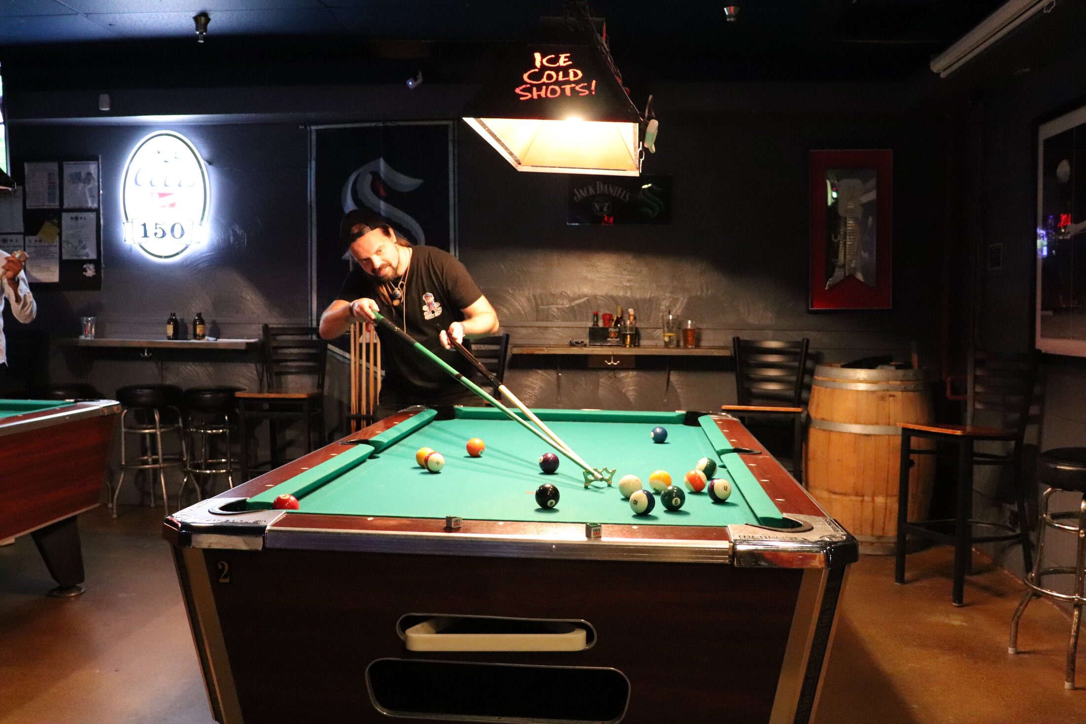 A player using the bridge to line up a shot on the pool table at Rooneys in Woodinville