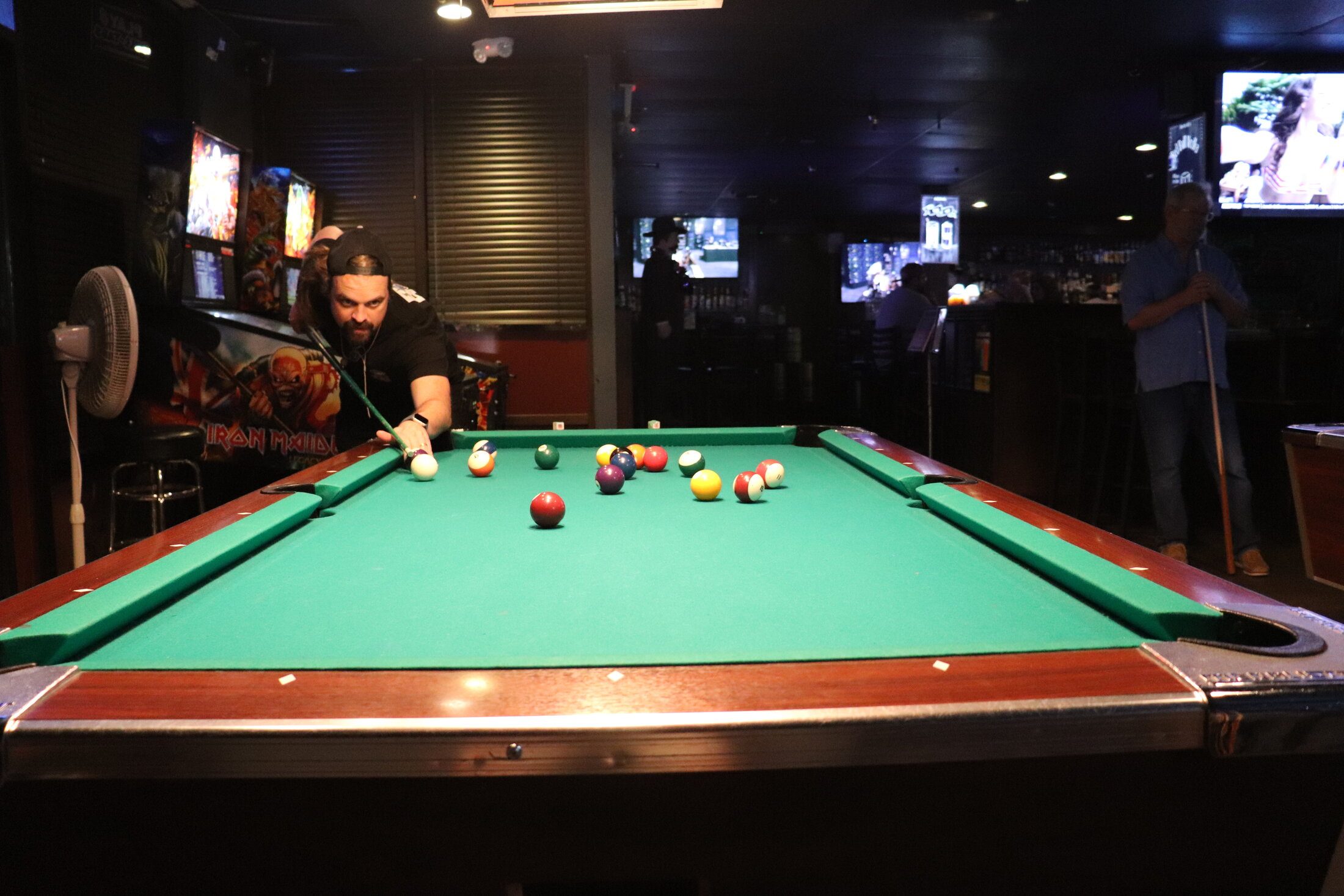The game room at Rooneys in Woodinville with the pool tables and pinball machine on a busy night