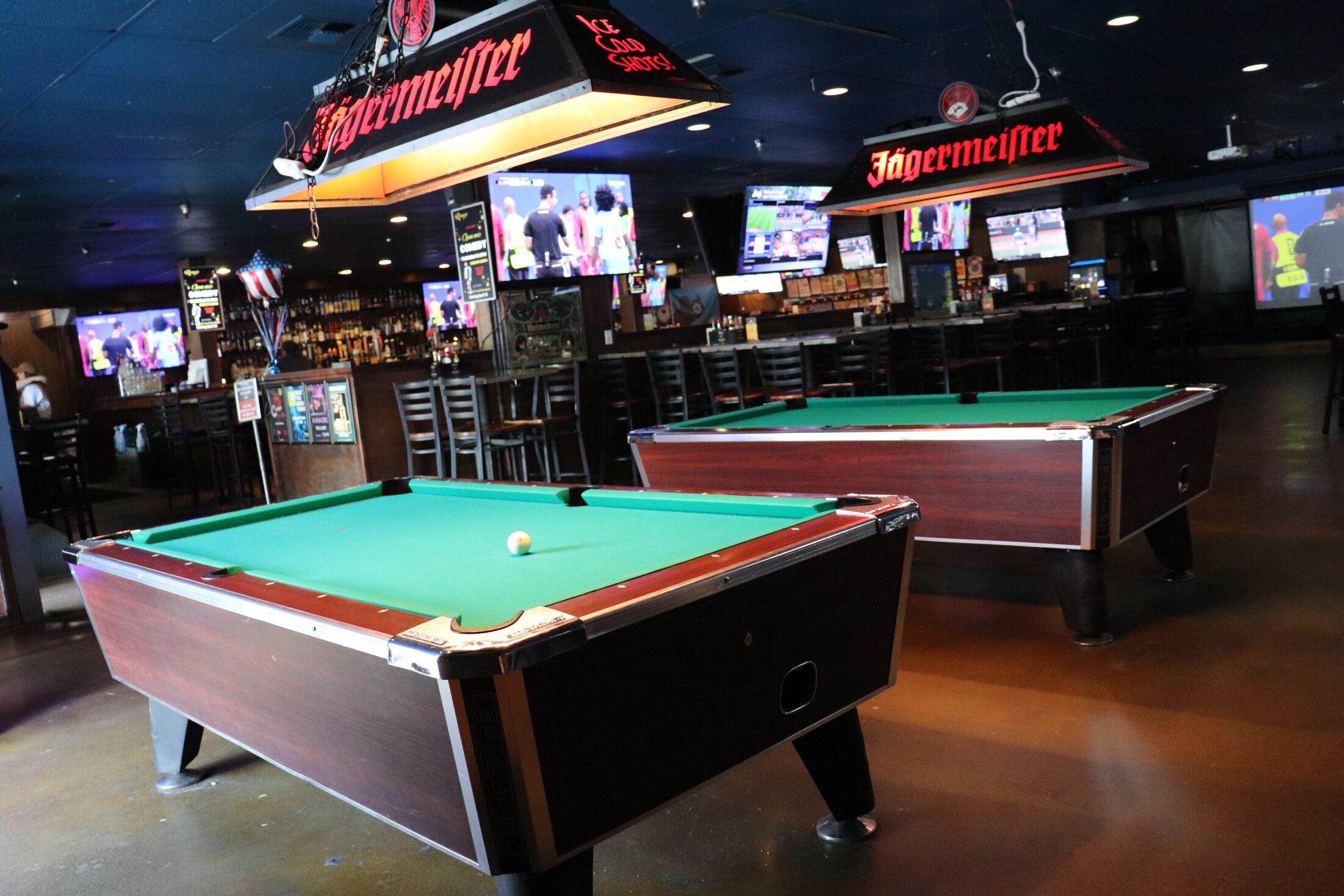 Pool tables with a view of the bar at Rooneys