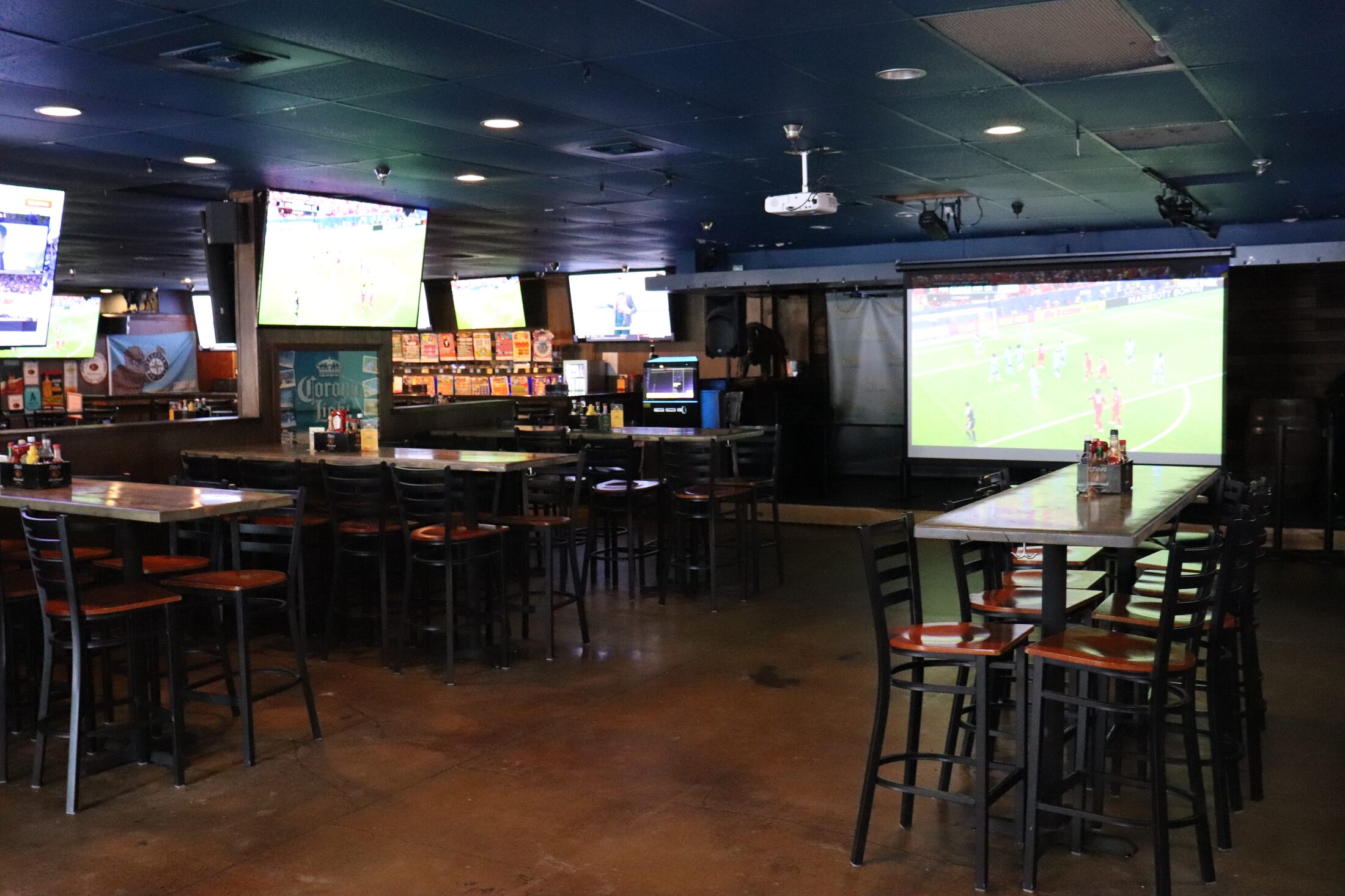 Big-screen projector and wall of TVs showing the match at Rooneys on game day