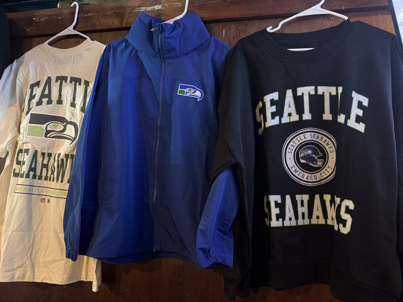 Seahawks gear on hangers at Rooneys in Woodinville, including a throwback windbreaker, crewneck sweatshirt and tee